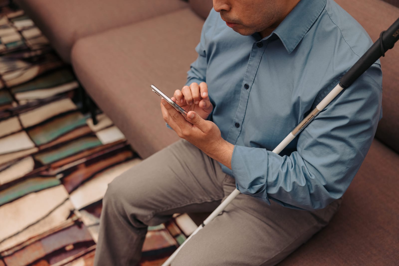 A businessman using text-to-speech on his phone, demonstrating assistive technology in action.